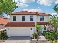 Two-story home with a red tile roof, two-car garage, and well-manicured landscaping at 332 Summer Place Loop, Clermont, FL 34714