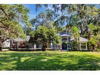Charming single-story home with a lush front lawn, mature trees, and a welcoming entrance framed by palms at 5301 Forest Breeze Ct, St Cloud, FL 34771
