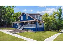 Charming blue two-story home featuring a welcoming front porch and a beautifully landscaped yard at 609 W Osceola St, Clermont, FL 34711