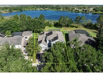 Stunning aerial view of a lakefront home with solar panels and lush landscaping in a desirable neighborhood at 6152 Meriwether, Winter Garden, FL 34787