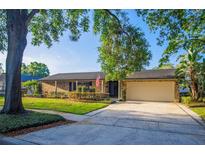 Charming single-story brick home with a well-manicured lawn and a spacious driveway leading to an attached two-car garage at 2108 Cree Trl, Casselberry, FL 32707