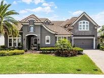 Beautiful two-story home with a well-manicured lawn, lush landscaping, and a gray exterior at 3863 Grassland Loop, Lake Mary, FL 32746