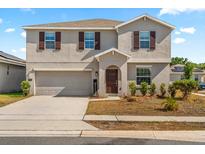 Charming two-story home features a welcoming entrance and a two-car garage at 542 Patton Loop, Bartow, FL 33830