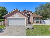 Charming single-Gathering home featuring a two-car garage and beautifully landscaped front yard, complemented by a sunny blue sky at 9301 Echo Run, Orlando, FL 32817
