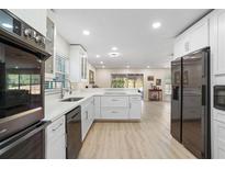 Open kitchen with modern appliances, white cabinets, and eat-in bar at 110 Tedworth Ct, Longwood, FL 32779