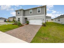 Charming two-story home featuring a brick paver driveway and an attached two-car garage at 16448 Winding Preserve Cir, Clermont, FL 34714