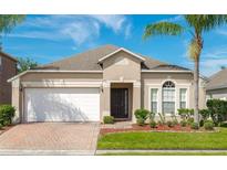 Charming single-story home with a well-manicured lawn, brick driveway, and attached two-car garage at 16843 Cedar Run Dr, Orlando, FL 32828