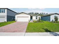 Charming single-story home featuring a brick driveway, well-maintained lawn, and neutral-colored exterior at 4709 Jasmine Cir, Leesburg, FL 34748