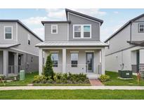 Charming two-story home boasts a modern facade, neat landscaping, and a welcoming front porch at 5127 Passion Flower Way, Winter Garden, FL 34787