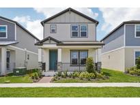 Charming two-story home featuring a covered front porch, landscaped yard, and a light gray exterior at 5133 Passion Flower Way, Winter Garden, FL 34787