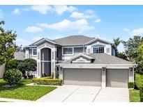 Stunning two-story home featuring a spacious three-car garage and well-manicured front lawn at 10033 Hart Branch Cir, Orlando, FL 32832