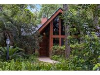 Charming home exterior featuring brick and a wall of windows, nestled among lush greenery at 2114 Bluff Oak St, Apopka, FL 32712