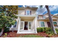 Inviting two-story townhome with double glass doors and manicured landscaping at 3238 Wish Ave, Kissimmee, FL 34747