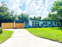 Beautiful home featuring a well-manicured lawn, fenced yard, and blue exterior at 511 S Alder Ave, Orlando, FL 32807