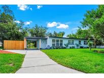 Charming single-story home featuring a well-manicured lawn, welcoming carport, and light blue exterior at 511 S Alder Ave, Orlando, FL 32807