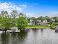 Stunning waterfront property with a large home, boat dock, and lush greenery at 645 Manor Rd, Maitland, FL 32751