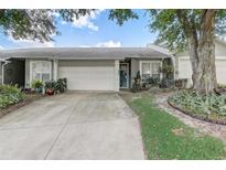 Charming single-story home with a two-car garage, featuring mature landscaping and a well-maintained lawn at 682 Lexington Dr, Clermont, FL 34711