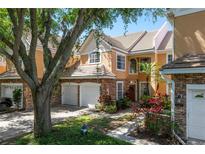 Beautiful townhome featuring stone accents, a tile roof, and a two-car garage at 7420 Cypress Grove Rd # 132, Orlando, FL 32819