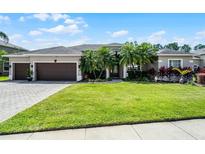 Charming single-story home with a three-car garage, lush landscaping, and a well-manicured lawn at 9126 Shadowbrook Trl, Orlando, FL 32825