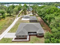 An aerial view of the home showing the surrounding property, garage, and RV parking at 10452 Log House Rd, Clermont, FL 34711