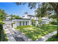 Stunning modern home with manicured lawn, dark trim, and lush landscaping at 1581 Forest Ave, Winter Park, FL 32789