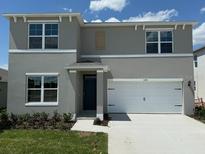 Charming two-story home with a two-car garage, well-manicured lawn, and a welcoming front entrance at 5291 Flameleaf St, Apopka, FL 32712