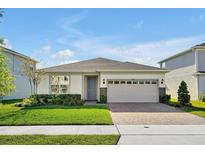 Beautiful single-story home featuring a well-maintained lawn, stone accents, and a two-car garage at 10002 Brown Burrow St, Orlando, FL 32829