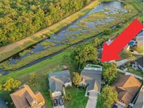 Stunning aerial view of a home with a private pool and lush backyard bordering a tranquil waterway at 1027 Dees Dr, Oviedo, FL 32765