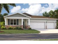 Beautiful single-Gathering home with a three-car garage, landscaped yard and classic architectural details at 12989 Trovita Dr, Grand Island, FL 32735