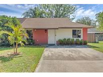 Charming single-story home with a well-manicured lawn and brick accents on the facade at 1397 Candlewyck Dr, Orlando, FL 32807