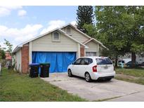Charming one-story home featuring light-colored siding, brick accents, and a front yard, offering curb appeal at 14057 Ithaca Way, Orlando, FL 32826