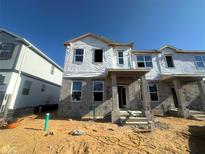 Unfinished two-story home with concrete block construction and visible framing, set against a clear blue sky at 15363 Burgtheater Dr, Winter Garden, FL 34787