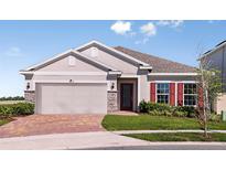 Charming single-story home with a two-car garage, stone accents, and a well-manicured lawn at 3529 Yarian Dr, Haines City, FL 33844