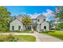 Beautiful two-story home featuring a well-manicured lawn, a palm tree, and a sleek, modern design at 532 Worthington Dr, Winter Park, FL 32789