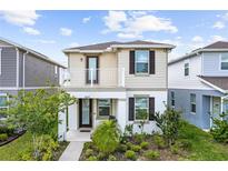 Two-story home featuring a charming balcony and well-maintained front yard at 5826 Wooden Pine Dr, Orlando, FL 32829