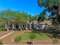 Charming home with a well-manicured lawn and a covered carport, surrounded by mature trees at 6037 Lake Erie Rd, Groveland, FL 34736