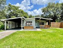 Charming single-story home featuring a covered carport and front porch, enhanced by a well-manicured lawn at 844 Rosalia Dr, Sanford, FL 32771