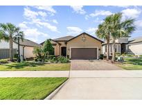 Charming single-story home with a well-manicured lawn, paver driveway, and lush tropical landscaping at 1335 Zeek Ridge St, Clermont, FL 34715