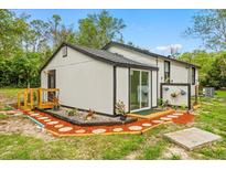 Charming home exterior with sliding glass door, wood accents, and beautiful landscaping at 151 Naranja Rd, Debary, FL 32713