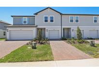 Charming townhome with a brick walkway, one-car garage, and well manicured lawn at 16403 Bird Of Paradise Ave, Clermont, FL 34714