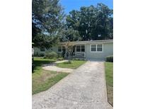 Charming single-story home with a concrete driveway, lush landscaping, and a welcoming front porch at 275 Virginia Dr, Winter Garden, FL 34787