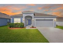 Charming single-story home with a well-maintained lawn, a two-car garage and a welcoming front entrance at 3532 Yarian Dr, Haines City, FL 33844