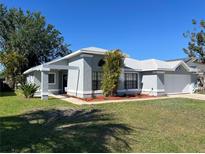Charming single-story home featuring a well-manicured lawn and attached two car garage at 377 Blue Bayou Dr, Kissimmee, FL 34743