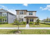 Charming two-story home with a well-manicured lawn and beautiful landscaping at 8573 Lamppost Ln, Orlando, FL 32832
