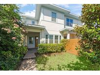 Charming two-story home with a well-maintained lawn, lush greenery, and inviting entryway at 8665 Theiler St, Orlando, FL 32827