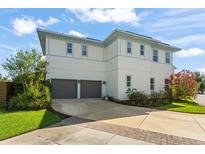 Two-story home featuring a large two car garage and well-maintained landscaping at 8665 Theiler St, Orlando, FL 32827