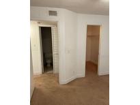 Cozy bedroom featuring neutral carpet, a bathroom, and a walk-in closet for ample storage at 11574 Westwood Blvd # 1126, Orlando, FL 32821