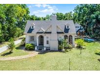 Charming two-story home with lush front yard, brick pathway, and traditional architectural details at 1210 S Clayton St, Mount Dora, FL 32757