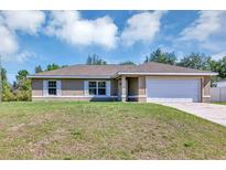 Charming single-story home showcasing a two-car garage, well-kept lawn, and traditional architecture at 1883 Sw 160Th Pl, Ocala, FL 34473