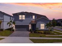 Charming two-story home features a well-maintained lawn, landscaped yard, and attached two-car garage at 1970 Summer Dr, Davenport, FL 33897